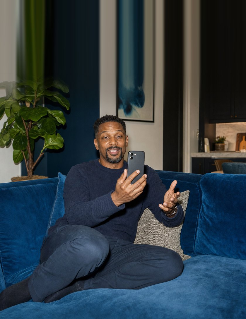 A man recording a heartfelt video message on his phone at home.